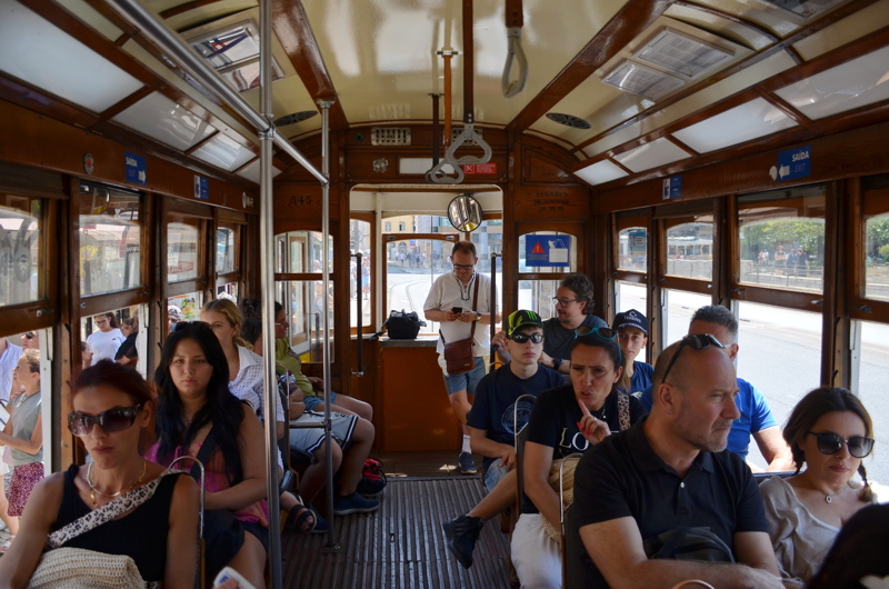 22 - The interior of a classic wooden tram in Lisbon, Portugal, capturing passengers seated inside as it navigates the historic city streets